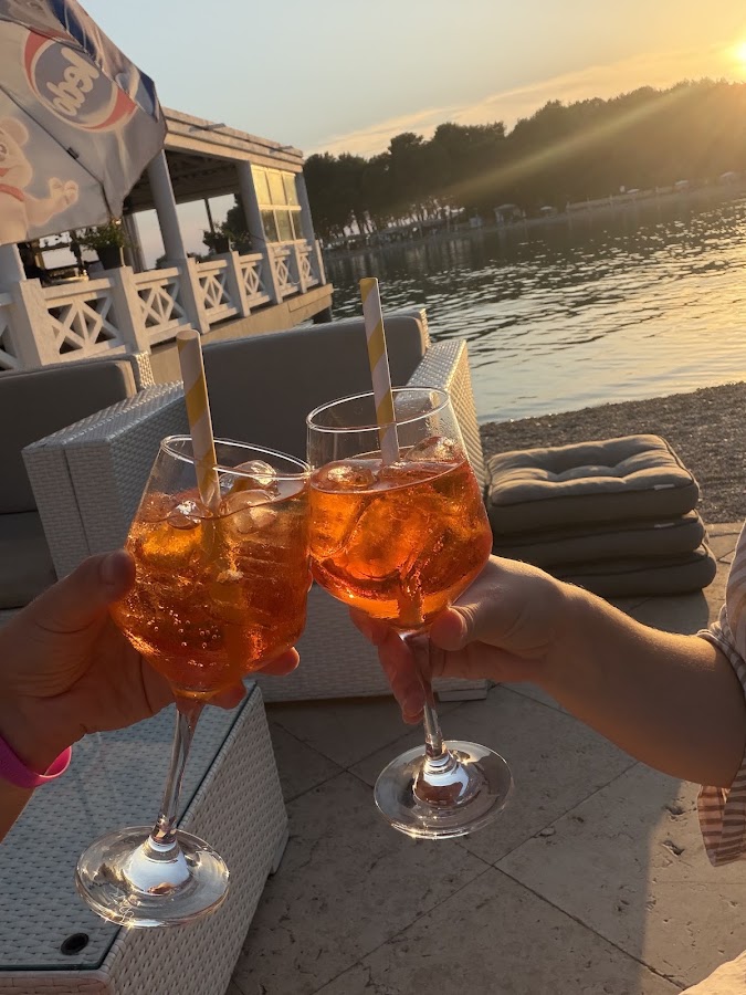 Dva Aperol Spritz koktela za nazdravljanje na terasi uz more