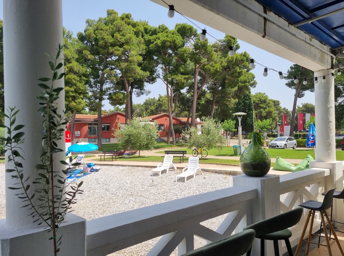 Terasa Tooki bara s pogledom na borovu šumu, ležaljke i odmaralište u Monterolu